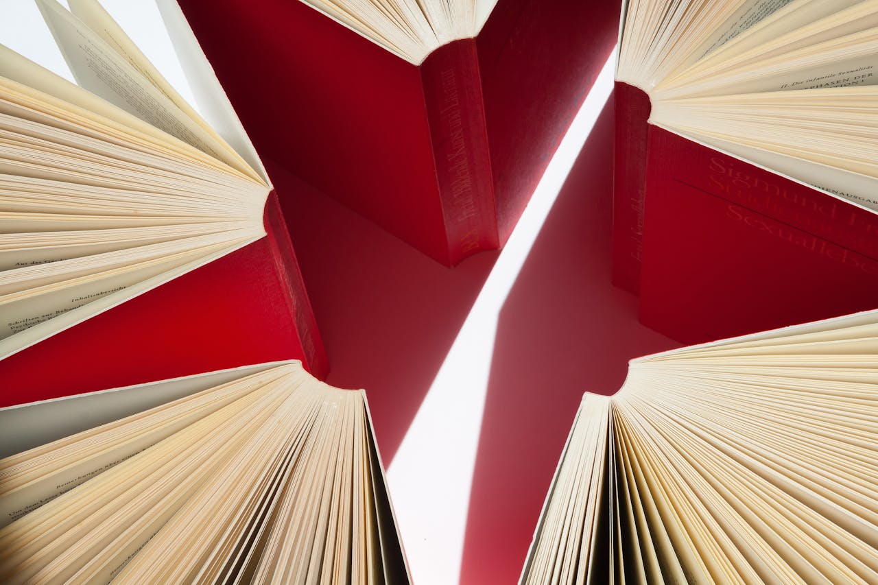 Crafting Captivating Headlines: Your awesome post title goes here An artistic display of open books with red covers arranged in a star-like pattern.